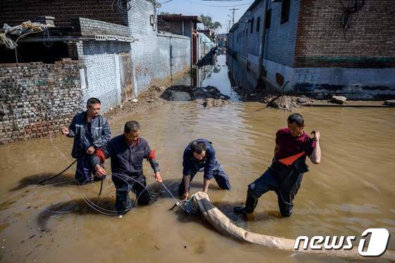 중국 산시성에 쏟아진 집중호우로 인해 홍수가 발생해 구조대원들이 도시에서 물을 빼내고 있다. © AFP=뉴스1 © News1 금준혁 기자
