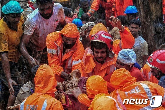 17일(현지시간) 인도 케랄라주를 강타한 폭우로 인해 산사태가 발생했다. 사진은 구조대원들이 산사태 사망자 시신을 옮기는 모습. © AFP=뉴스1 © News1 신윤하 기자