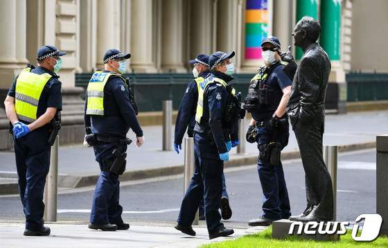 호주 빅토리아주 멜버른에서 경찰관들이 존 캐인 전 총리 동상을 점검하고 있다. (본문과 관련없음) 2020.09.26 © AFP=뉴스1