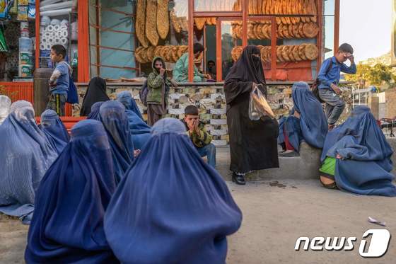 아프가니스탄 카불에서 부르카를 입은 여성들이 빵 기부를 받기 위해 빵집 앞에서 기다리고 있다. © AFP=뉴스1 © News1 노선웅 기자