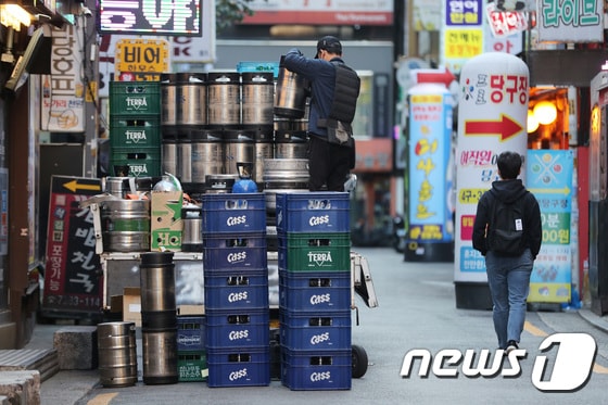 정부가 '위드코로나'와 관련해 구체적인 방역 완화 계획안을 발표한 25일 서울의 한 유흥거리에서 관계자가 맥주 박스를 옮기고 있다. 2021.10.25/뉴스1 © News1 이성철 기자