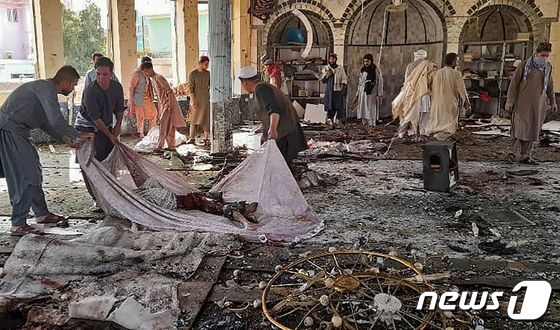 아프가니스탄 북동부 쿤드즈주 한 시아파 모스크에서 2021년 10월 8일(현지시간) 자폭 테러가 일어난 가운데, 현장에서 시신이 수습되는 모습. © AFP=뉴스1
