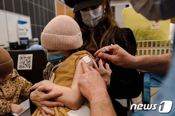 24일 (현지시간) 캐나다 몬트리올에 마련된 코로나19 백신 접종소에서 7세 어린이가 화이자 백신을 맞고 있다. © AFP=뉴스1 © News1 우동명 기자