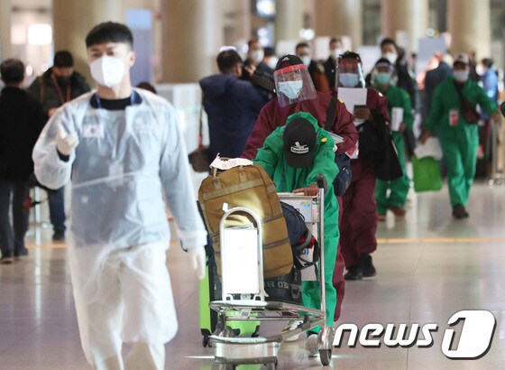 28일 인천공항 1터미널에서 방역복을 입은 해외 입국자들이 이동하고 있다. 2021.11.28/뉴스1 © News1 이성철 기자