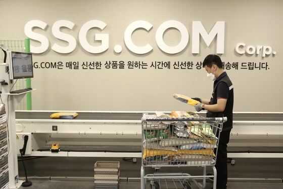 작업자가 자동화 소터에 상품을 투입하는 모습(SSG닷컴 제공)© 뉴스1