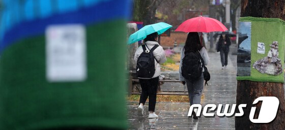 겨울을 재촉하는 비가 내린 30일 전북 전주시 한옥마을에서 우산을 쓴 시민들이 발걸음을 옮기고 있다. 2021.11.30/뉴스1 © News1 유경석 기자