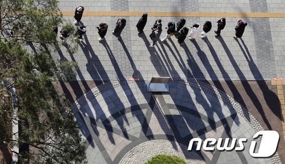 13일 오전 서울 송파구보건소에 마련된 코로나19 선별진료소에서 시민들이 길 건너편까지 줄을 서서 검사를 기다리고 있다. 2021.12.13/뉴스1 © News1 박세연 기자