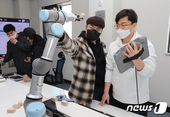 로봇전자과 학생들이 유니버설로봇사의 협동로봇을 이용하여 실습을 하고 있다. (폴리텍 로봇캠퍼스 제공) © 뉴스1