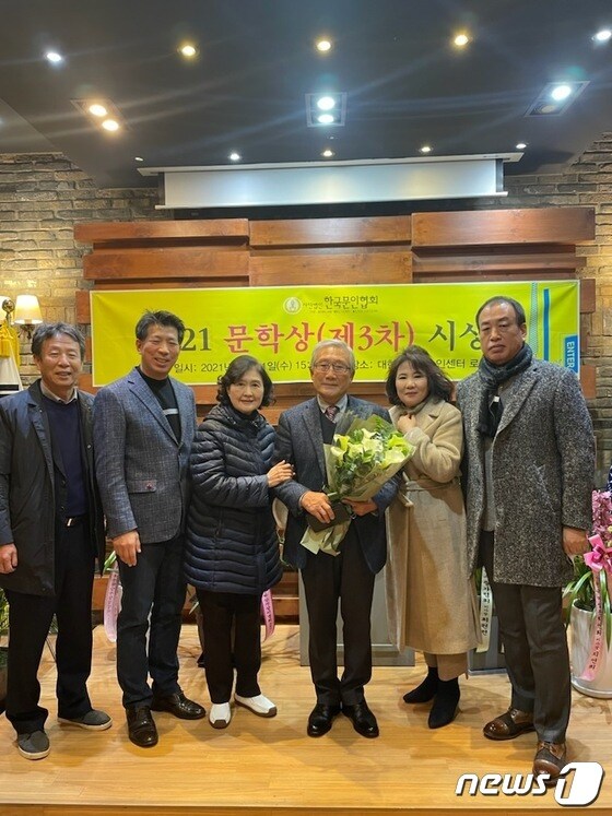 한국문학상을 받은 박찬선 시인이 꽃다발을 들고 축하를 받고 있다.(상주시 제공) © 뉴스1