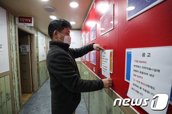 6일 오후 서울 시내의 한 학원에서 관계자가 방역패스 관련 안내문을 교실 등에 붙이고 있다. 2021.12.6/뉴스1 © News1 성동훈 기자