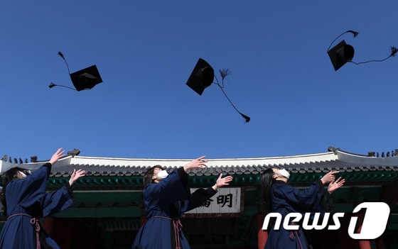 지난 2월17일 서울 종로구 성균관대 문묘 명륜당에서 전통 학위복을 입은 졸업생들이 학사모를 하늘 높이 던지고 있다. /뉴스1 © News1 오대일 기자