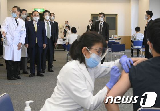 스가 요시히데 일본 총리가 18일 (현지시간) 국영 도쿄 메디컬 센터에서 코로나19 화이자 백신 접종 모습을 지켜보고 있다, © AFP=뉴스1 © News1 우동명 기자
