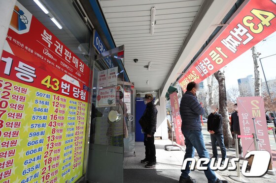 16일 오전 서울 노원구의 복권판매점 앞에 복권을 사기 위한 시민들이 줄을 서 있다.  2021.3.16/뉴스1 © News1 박정호 기자