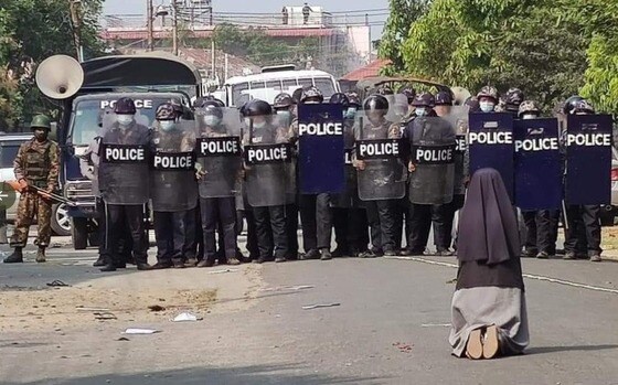 안 로사 누 타웅 수녀가 무장한 경찰들 앞에 무릎을 꿇고 시위대에 사격을 하지 말아달라고 호소하고 있다. (찰스 마웅 보 추기경 트위터 갈무리/뉴스1)