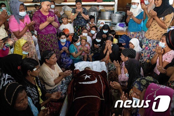 1일 가족과 친척들이 반쿠데타 시위에 참여했다가 사망한 한 무슬림 여성의 시신 옆에서 기도하고 있다. © AFP=뉴스1