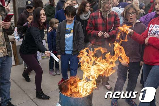 미국 아이다호주에서 마스크 착용 의무화 조치에 반대하는 시위대가 마스크 화형식을 벌였다. © AFP=뉴스1