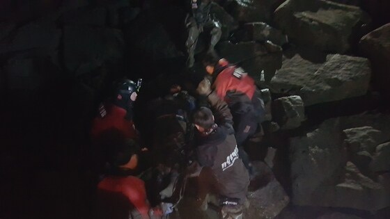 보령해경과 소방이 홍성 어사항 인근 갯벌에 고립된 한 남성을 구조한 뒤 방파제로 옮기고 있다.(보령해경 제공)© 뉴스1