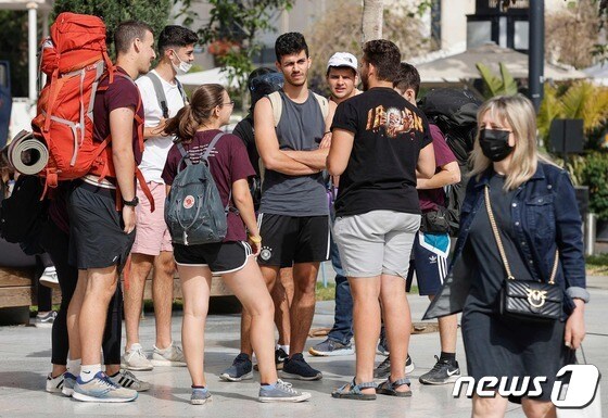 18일(현지시간) 야외에서 마스크 착용 의무 해제로 이스라엘 텔아비브 거리의 젊은이들이 '노 마스크' 상태로 대화를 하고 있다. © AFP=뉴스1 © News1 우동명 기자