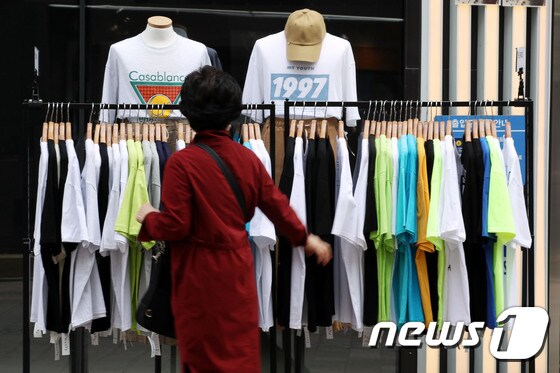 전국 대부분 지역이 25도 이상으로 오르며 초여름 날씨를 보인 22일 오후 서울 중구 명동에서 한 시민이 여름옷을 살펴보고 있다. 2021.4.22/뉴스1 © News1 이광호 기자