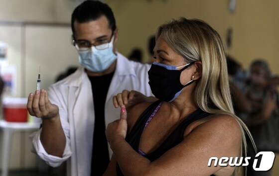 브라질 리우데자네이루에서 코로나19 백신 접종을 하고 있는 한 여성. © 로이터=뉴스1