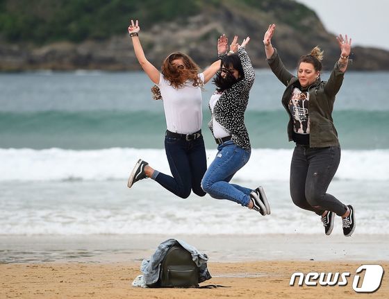 9일(현지시간) 7개월만에 코로나19 규제 조치가 해제된 스페인 산세바스티안의 라콘차 해변에서 여성들이 사진을 찍기 위해 모래사장을 뛰어오르며 포즈를 취하고 있다. © AFP=뉴스1 © News1 우동명 기자