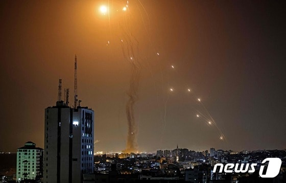 11일(현지시간) 팔레스타인 자치 지역인 가자지구 상공에서 무장 정파 하마스가 쏜 로켓포를 이스라엘 방공시스템 아이언돔의 미사일이 요격을 하고 있다. © AFP=뉴스1 © News1 우동명 기자