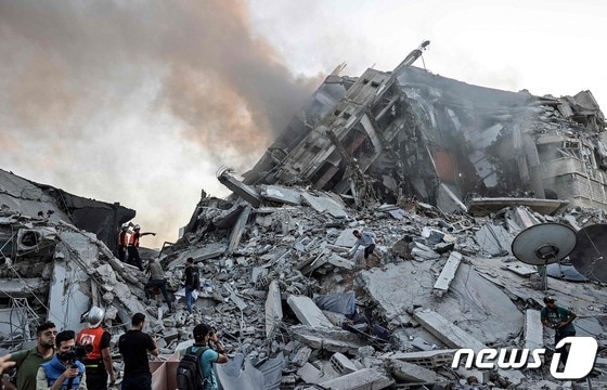 12일(현지시간) 팔레스타인 무장 정파 하마스가 지배하는 가자지구에서 이스라엘군의 공습에 명중된 타워의 무너져내린 모습이 보이고 있다. © AFP=뉴스1 © News1 우동명 기자
