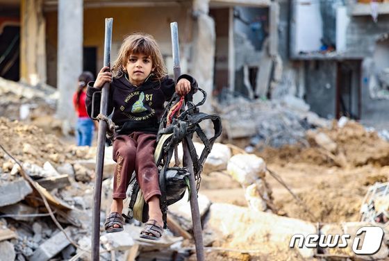 이스라엘의 공습으로 무너진 팔레스타인 가자지구의 건물 잔해 앞에 있는 어린 아이. © AFP=뉴스1