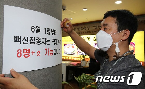 5월31일 대전 서구에 위치한 식당에서 식당 주인이 백신접종자는 직계가족 8인 이상 가능하다는 안내문을 붙이고 있다.  2021.5.31/뉴스1 © News1 김기태 기자