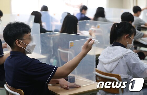 경기 수원 한 중학교에서 학생들이 가림판을 소독하고 있다. 2021.6.14/뉴스1 © News1 김영운 기자
