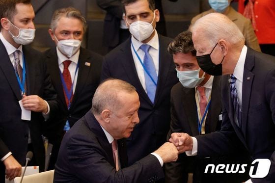 14일(현지시간) 북대서양조약기구(나토) 정상회의에서 만난 조 바이든 미국 대통령과 레제프 타이이프 에르도안 터키 대통령이 주먹인사를 나누고 있다. © AFP=뉴스1