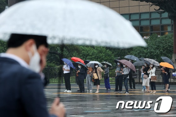 18일 오전 서울 종로구 광화문네거리에서 시민들이 우산을 쓴 채 출근하고 있다.. 2021.6.18/뉴스1 © News1 조태형 기자