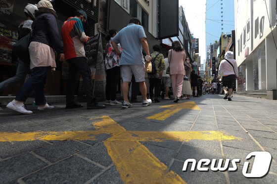 서울 명동거리의 한 식당에서 시민들이 식사를 하기 위해 줄을 서 있다./뉴스1 © News1 신웅수 기자