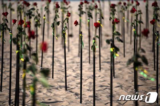20일(현지시간) 브라질 리우데자네이루 해변에서 50만 명을 넘은 코로나19 사망자를 장미꽃으로 애도하는 퍼포먼스가 벌어지고 있다. © AFP=뉴스1 © News1 우동명 기자
