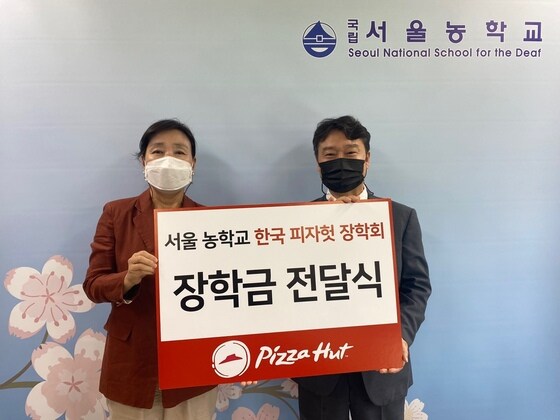 김은숙 서울농학교 교장(왼쪽)과 김진영 피자헛 대표이사가 장학금 전달식을 하고 기념사진을 촬영하고 있다. (피자헛 제공) © 뉴스1
