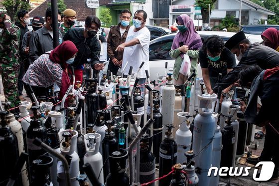 14일(현지시간) 인도네시아 욕야카르타에서 주민들이 코로나19 환자용 산소통을 충전하기 위해 모여 있다. © AFP=뉴스1 © News1 우동명 기자