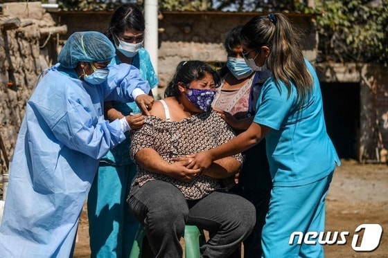 의료진들이 지난 7월2일 페루 남부에서 한 여성에게 화이자 백신을 접종하고 있다. © AFP=뉴스1