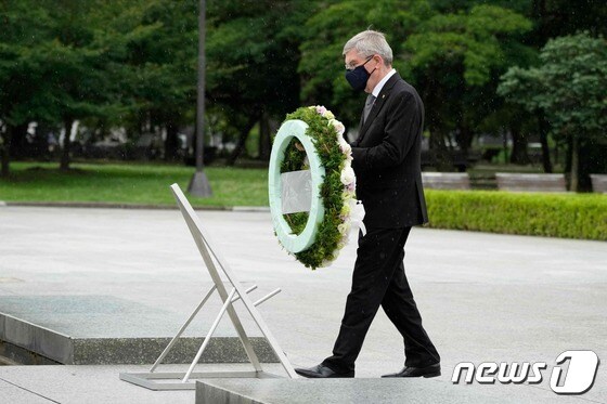 지난달 16일 히로시마 평화기념공원을 방문한 토마스 바흐 IOC 위원장이 원폭 희생자 위령비에 헌화하고 있다. © AFP=뉴스1