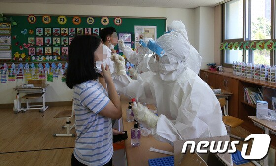 의료진이 대전 한 초등학교 학생들을 대상으로 신종 코로나바이러스 감염증(코로나19) 검사를 하고 있다. 2021.7.22/뉴스1 © News1 김기태 기자