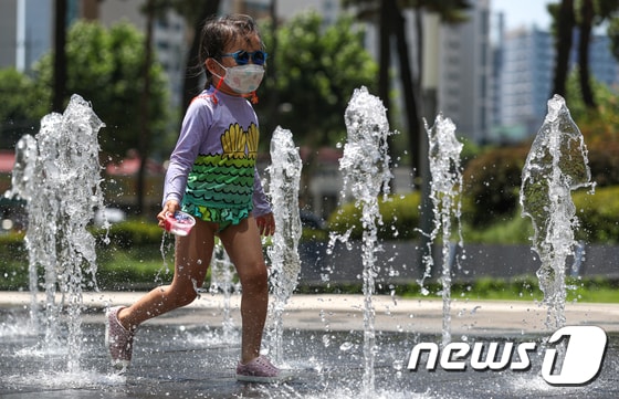 연일 찜통더위가 계속되는 22일 오후 서울 도심의 한 바닥분수에서 어린이들이 즐거운 시간을 보내고 있다. 2021.7.22/뉴스1 © News1 성동훈 기자