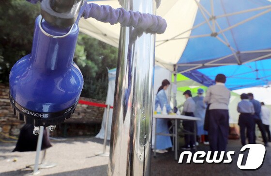 연일 무더위가 이어지고 있는 23일 서울 양천구 파리공원에 설치된 코로나19 찾아가는 선별진료소에서 시민들이 순서를 기다리고 있는 가운데 지열을 식히기 위한 호스에서 물방울이 떨어지고 있다. 2021.7.23/뉴스1 © News1 이동해 기자