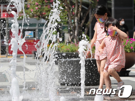 전국 대부분 지역에 폭염특보가 발효된 26일 서울의 한 분수대를 찾은 아이가 더위를 식히고 있다. 2021.7.26/뉴스1 © News1 이성철 기자