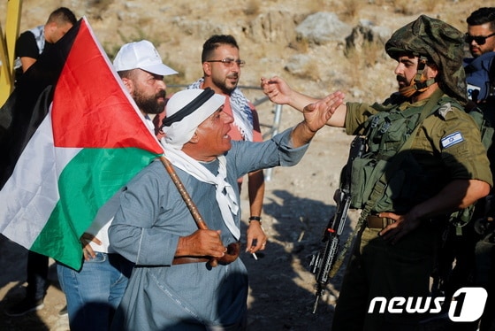 27일(현지시간) 서안지구에서 이스라엘 정착촌 건설에 반대하는 팔레스타인 주민이 이스라엘 군인에게 항의하고 있다. © 로이터=뉴스1 © News1 이정후 기자