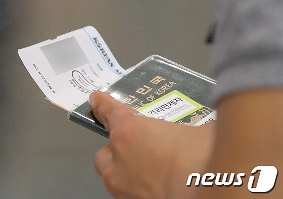 지난달 7일 인천국제공항에서 한 시민의 여권에 자가격리면제 스티커가 붙어 있다.  2021.7.7/뉴스1 © News1 이성철 기자