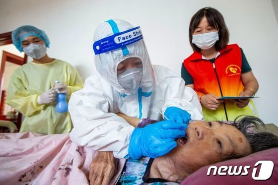 8일 중국 난퉁시에서 의료진이 요양시설에 거주하는 사람들을 대상으로 코로나19 진단검사를 실시하고 있다.  AFP=뉴스1