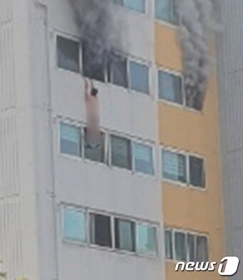 화재 당시 A씨가 창문에 매달려 있는 모습.(독자 제공).2021.8.2/© 뉴스1