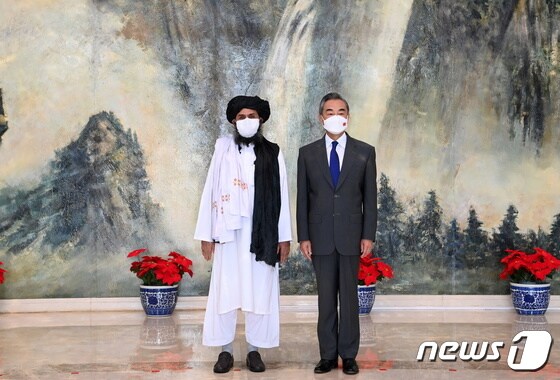 왕이 중국 외교부장(오른쪽) 물라 압둘 가니 바라다르 탈레반 2인자 © 로이터=뉴스1 © News1 박형기 기자