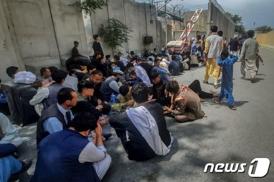 17일(현지시간) 탈레반이 아프가니스탄 정권을 재장악한 카불의 프랑스 대사관 밖에서 출국하려는 아프간인들이 앉아 있다. © AFP=뉴스1 © News1 우동명 기자