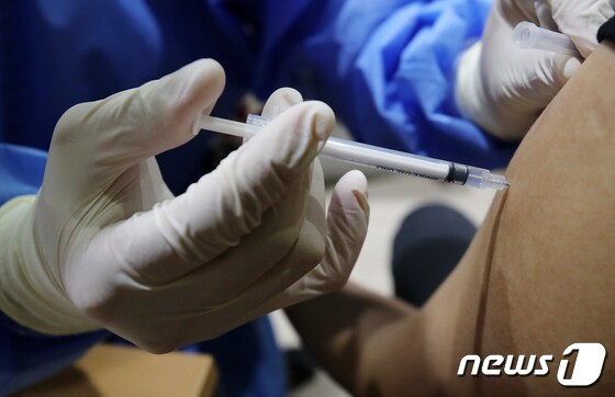 지난달 20일 서울 종로구 코로나19 예방접종센터에서 의료진이 시민에게 백신을 접종하고 있다.  2021.8.21/뉴스1 © News1 김진환 기자