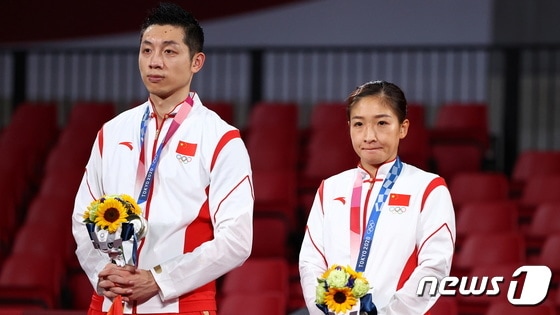 중국 탁구 혼합 복식조가 은메달을 따 시상대에 올랐지만 표정이 어둡다. © 로이터=뉴스1 © News1 박형기 기자